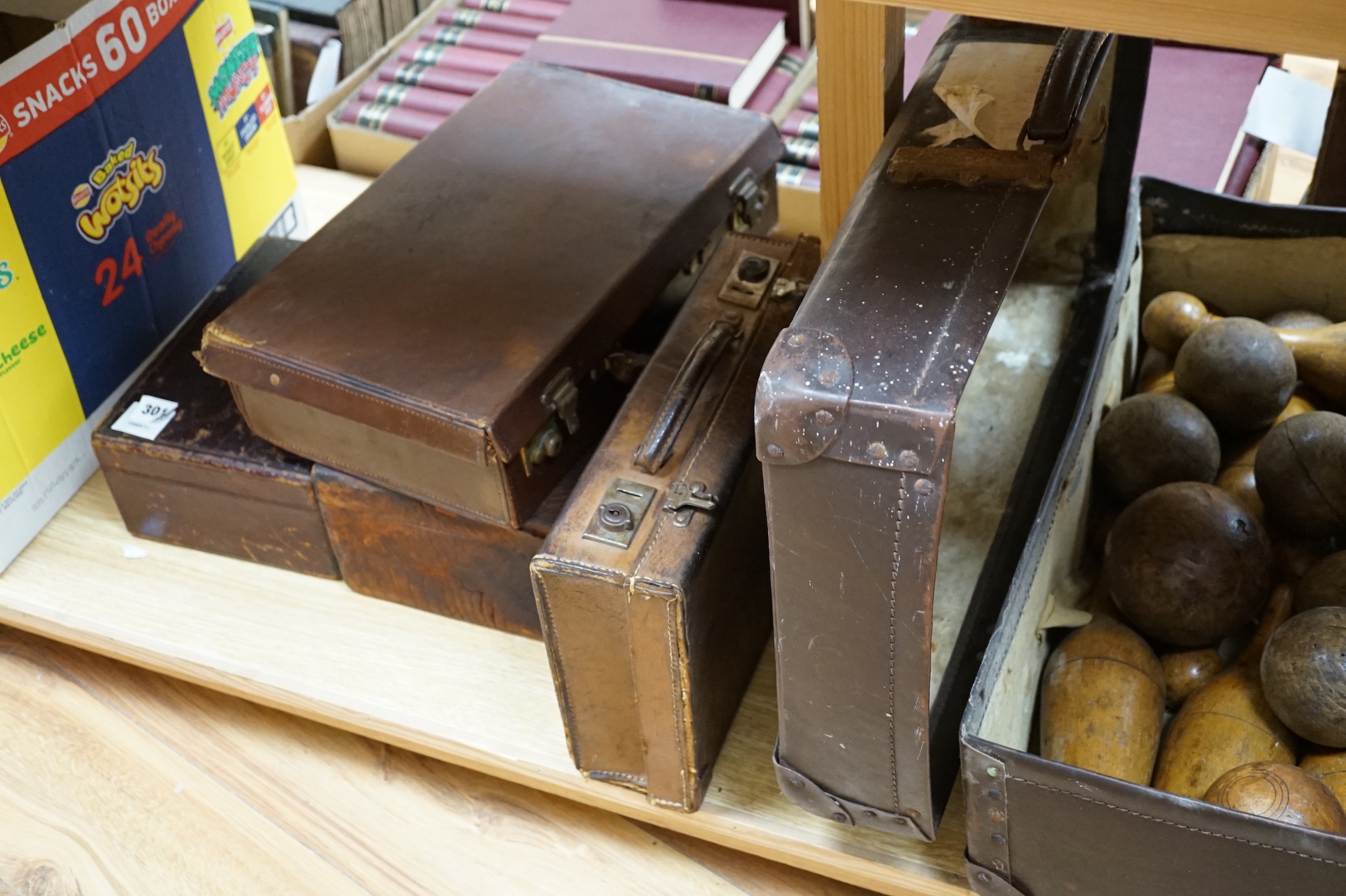 Seven vintage leather suitcases and a leather writing box (locked), the largest 60cm wide